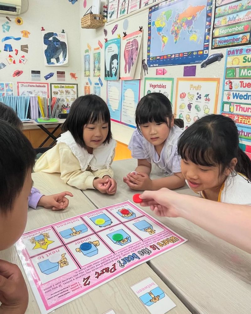 英語のゲームボードで遊びながら学ぶ子どもたち